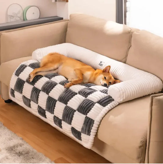Dog lying on a checkered pet bed in a living room.
