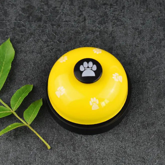 Yellow bell with paw print design on a dark surface
