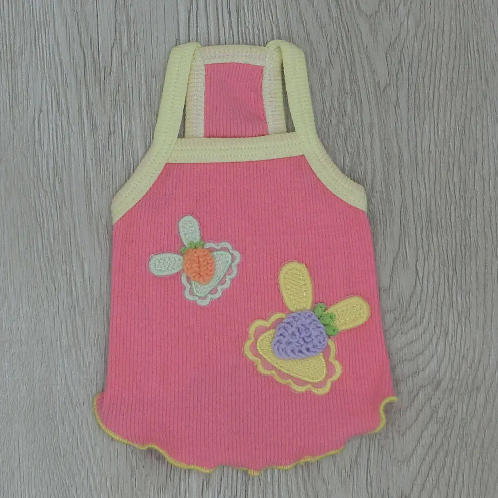 Pink children's dress with floral designs on a wooden surface