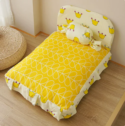 Yellow bedspread with a floral pattern on a wooden floor.