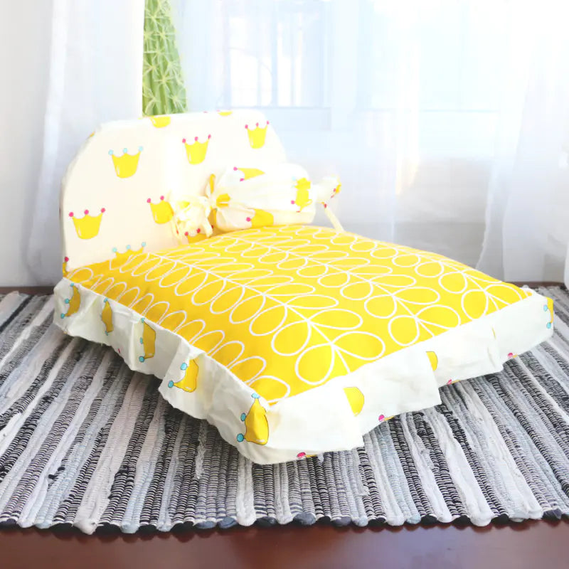 Yellow cushion with a pattern on a striped rug