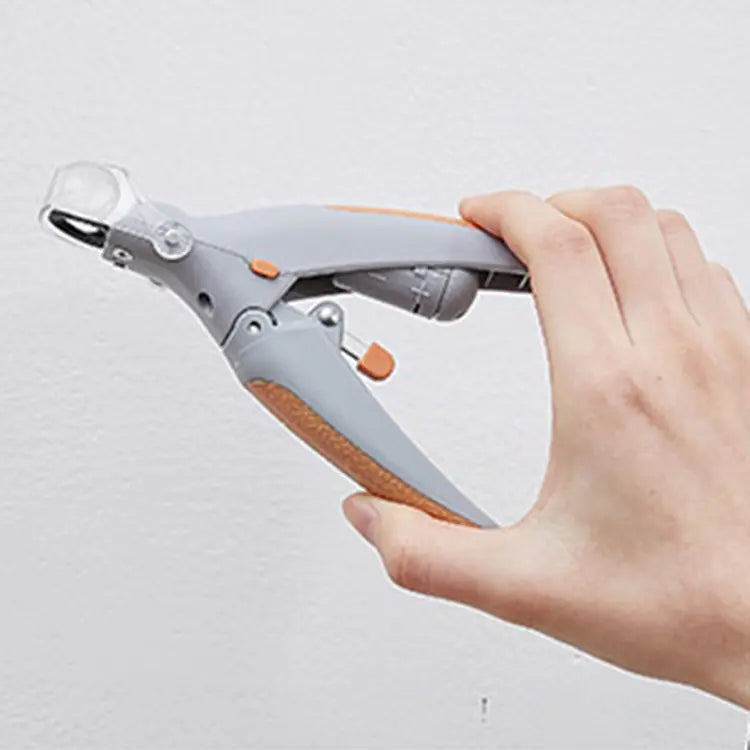 Hand holding a gray and orange tool against a light gray background