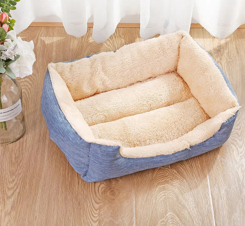 Pet bed with plush beige interior and blue exterior on a wooden floor.