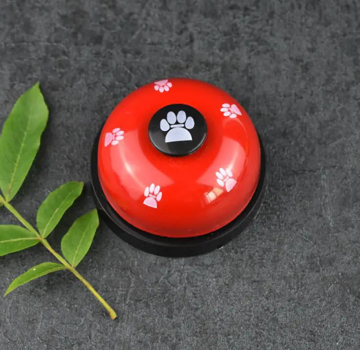 Red bell with paw print design on a dark surface
