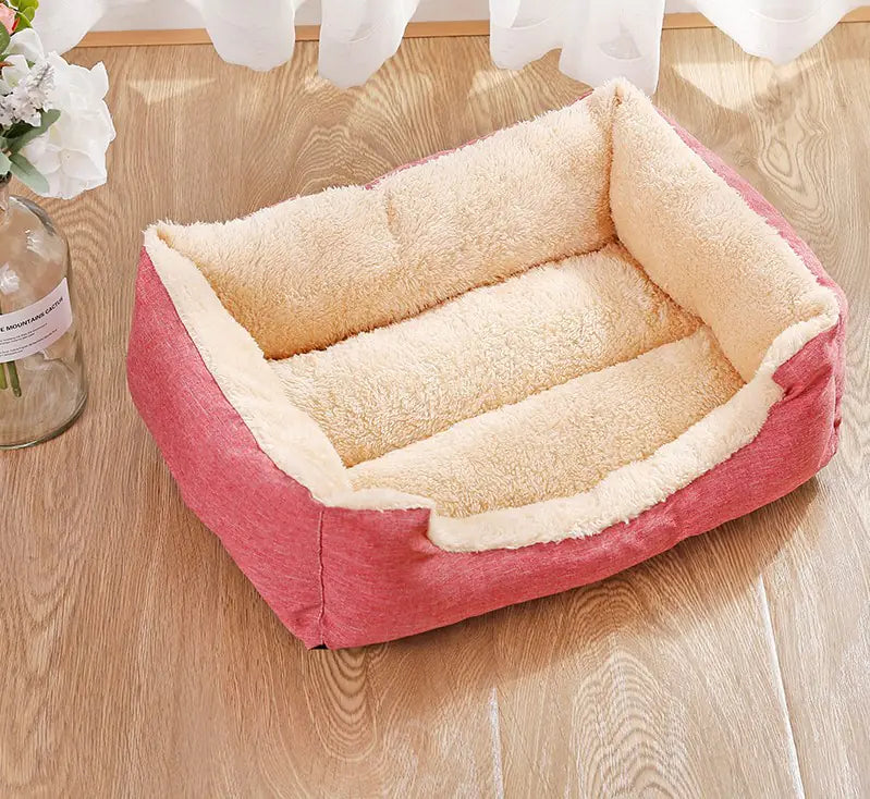 Pink pet bed with beige interior on a wooden floor