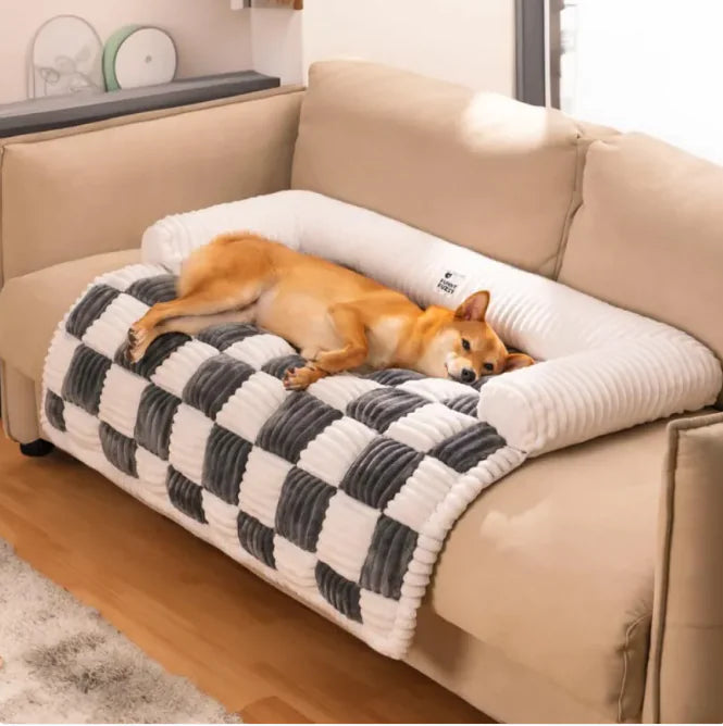 Dog lying on a checkered pet bed in a living room.
