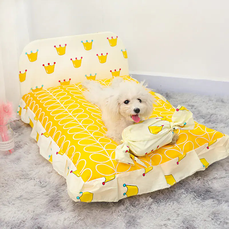 Small white dog on a yellow and white patterned pet bed.