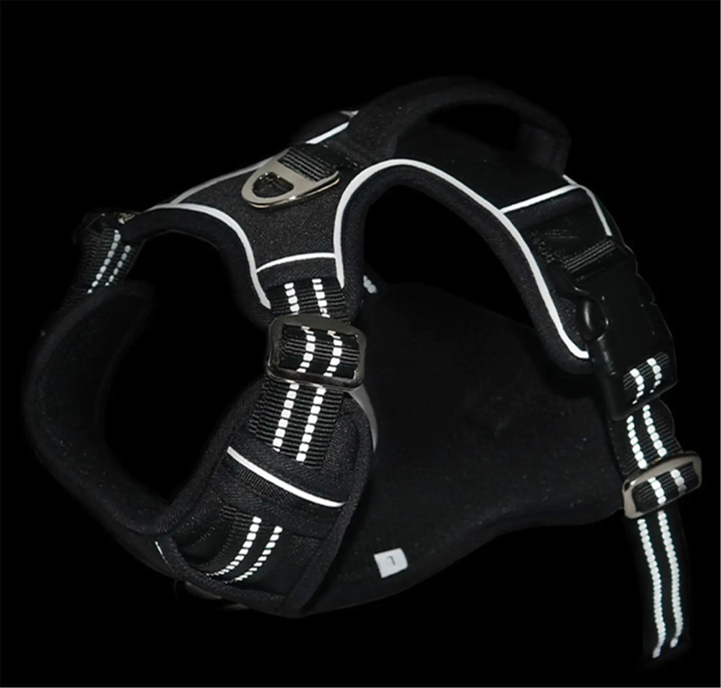 Black dog harness with reflective stripes on a black background
