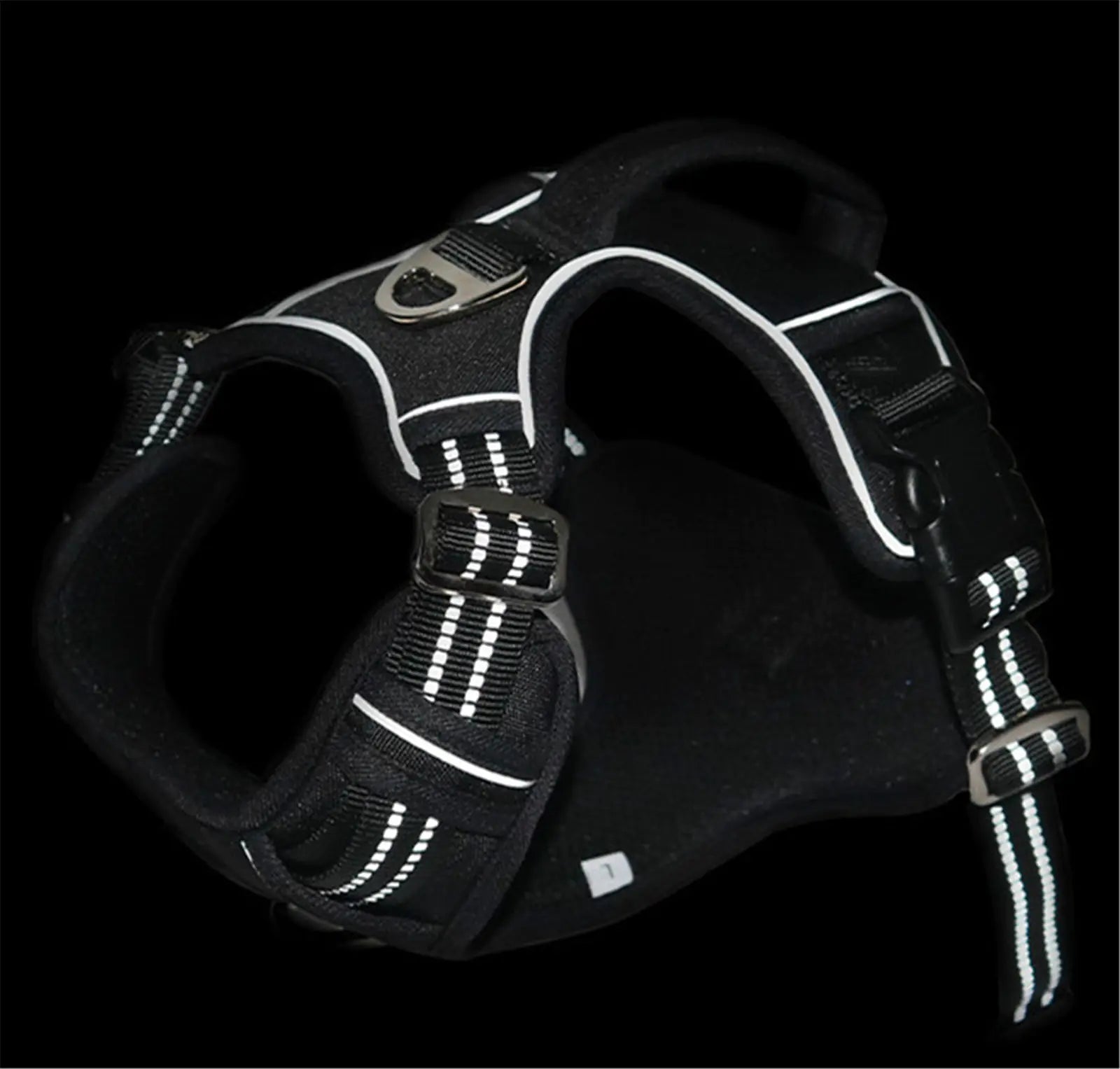 Black dog harness with reflective stripes on a black background