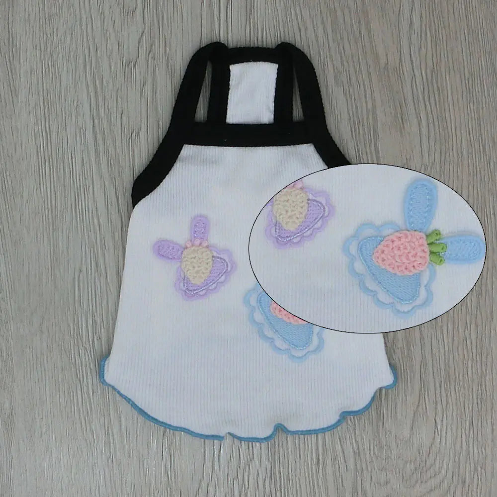 White apron with embroidered strawberry design on a wooden surface