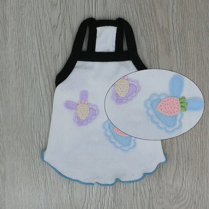 White apron with embroidered strawberry design on a wooden surface