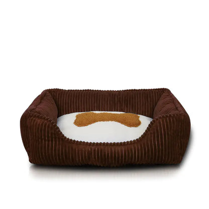 Brown pet bed with a white cushion and brown bone design on a white background