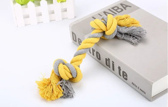 Yellow and gray knotted rope toy on a book