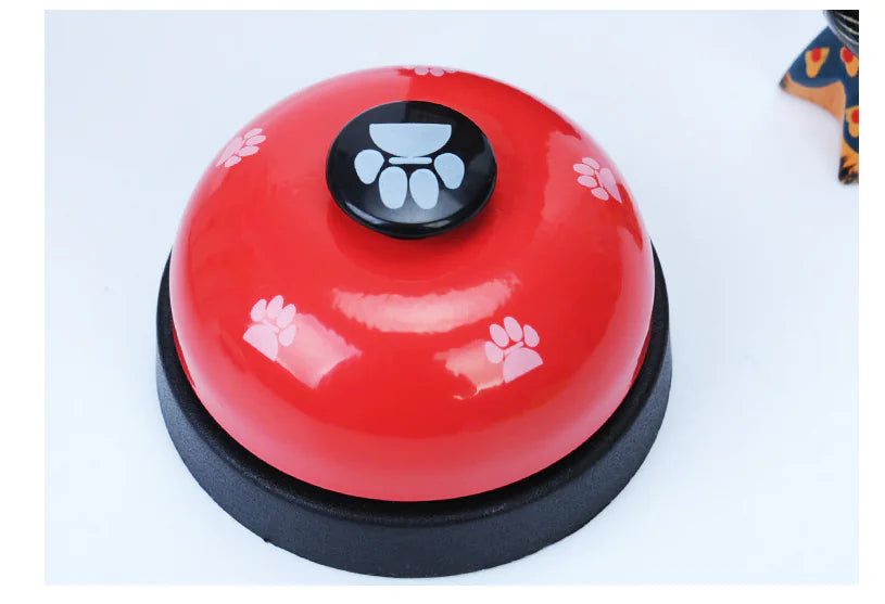 Red bell with black base and paw print design on a white background