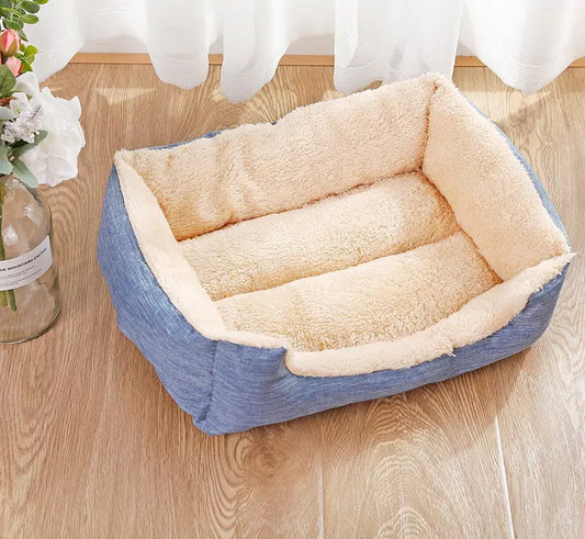 Pet bed with plush beige interior and blue exterior on a wooden floor.